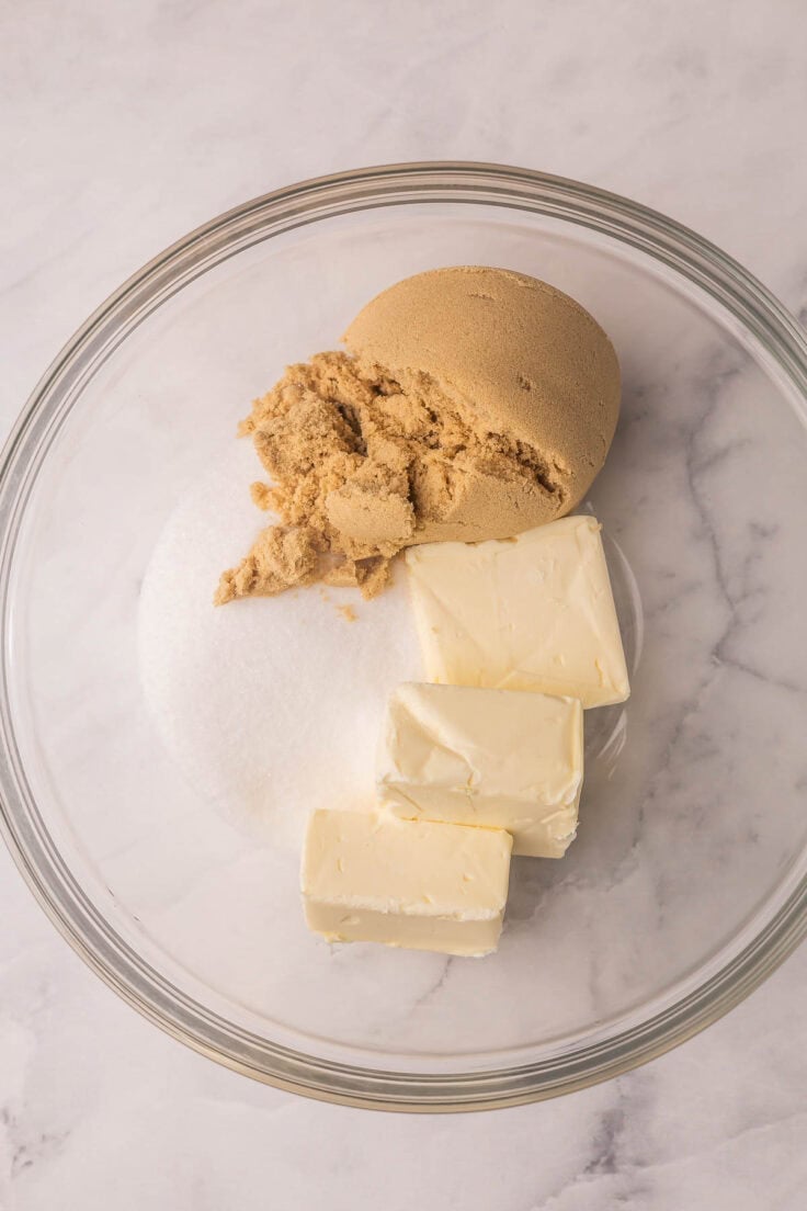unmixed butter and sugars in glass mixing bowl.