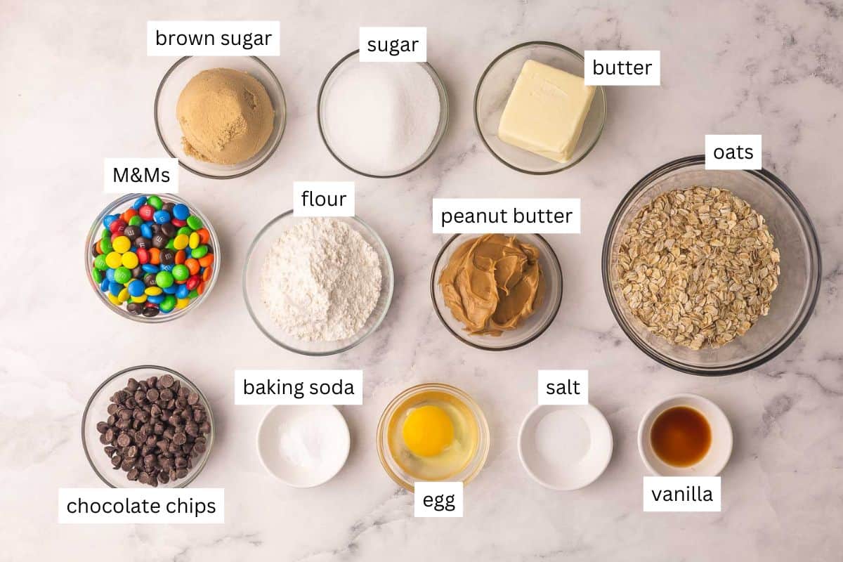 Classic Monster Cookies are loaded with creamy peanut butter, chewy old-fashioned oats, melty chocolate chips, and colorful M&Ms. They're the perfect cookie for those who like a little bit of everything! #cookie #recipe | cookie recipe | cookies recipe | peanut butter cookies | oatmeal cookies | m&m cookies | dessert recipe | baking recipe ingredients needed for monster cookies in bowls.