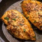 square image of pan fried chicken breasts with garlic butter.