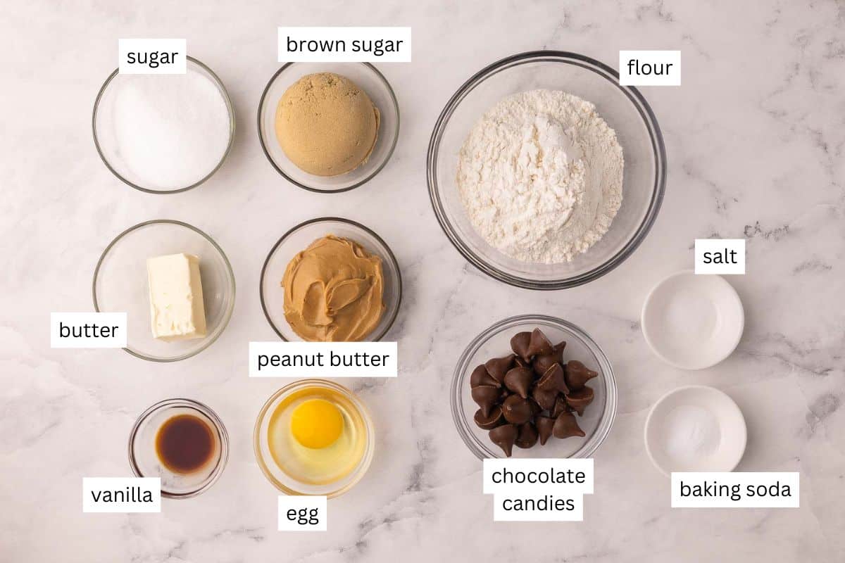 Peanut Butter Blossoms are made with a chewy peanut butter cookie base and a chocolate kiss pressed into the middle. They’re ready in just over 30 minutes and are the perfect nostalgic cookies for holidays, parties, or just because. #cookies #baking #dessert | cookie recipe | cookies | peanut butter cookies | peanut butter recipes | peanut butter chocolate ingredients needed for peanut butter blossoms in bowls.