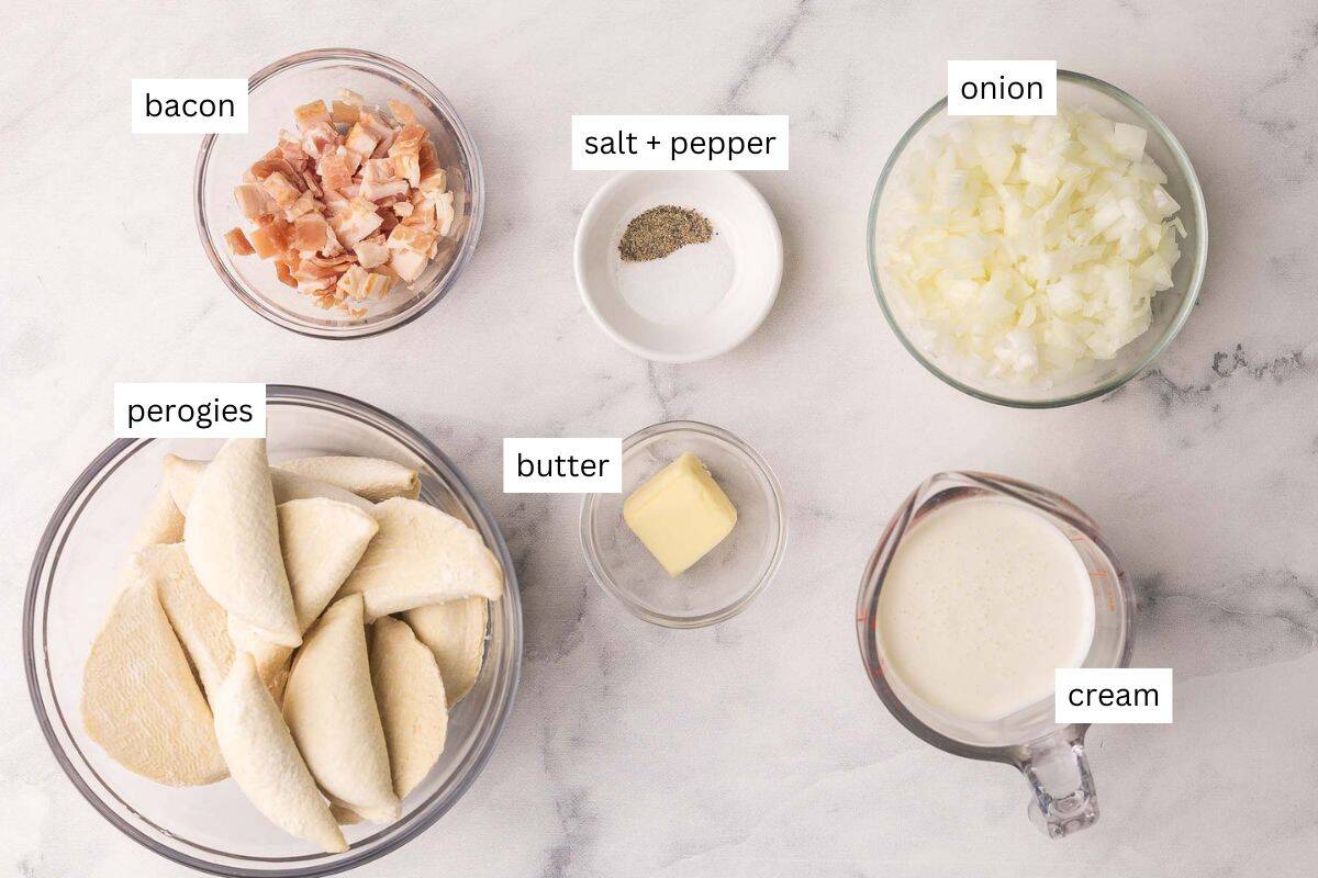 This Perogies recipe with Bacon and Onions recipe is made with frozen perogies swimming in a creamy sauce with smoky bacon and onions. Ready in 35 minutes, it's the perfect side dish for the holidays or whenever you're craving something comforting. | dinner | recipe | easy dinner ideas | pierogi | comfort food | skillet meals ingredients needed for perogies with bacon and onions in bowls.