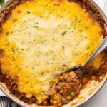 large dish of shepherds pie with a spoon in it.