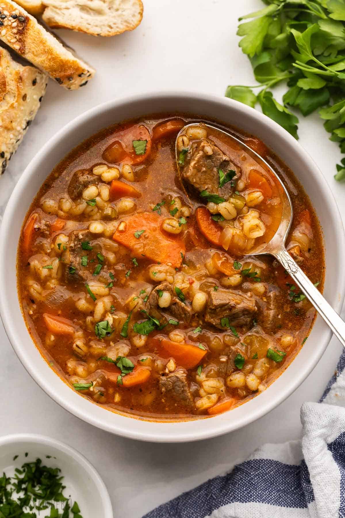large bowl of beef barley soup with a spoon in it.