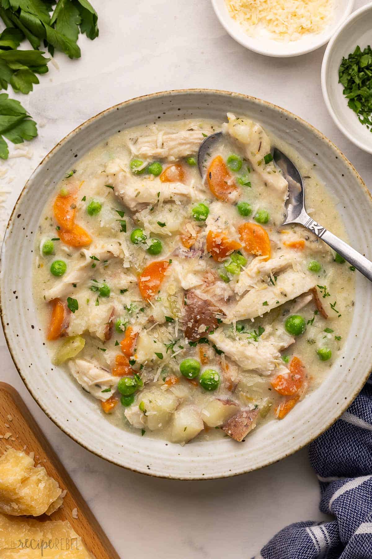 a speckled bowl full of stew and topped with shredded parmesan.