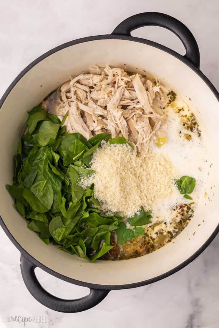 parmesan and other ingredients added to large soup pot.