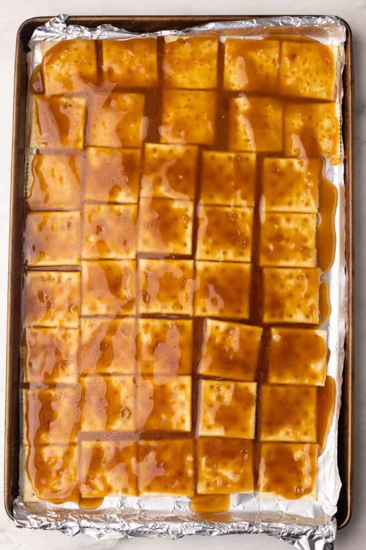 pan of crackers with toffee sauce spread over the top.