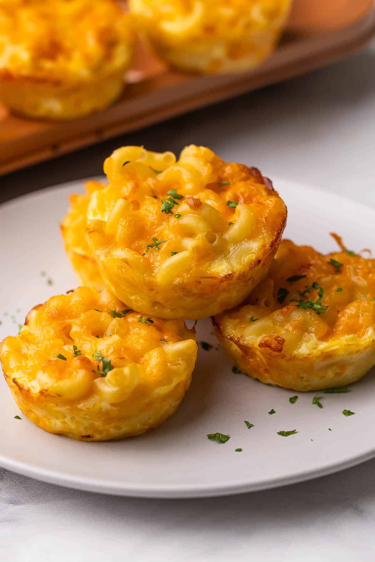 baked mac and cheese cups topped with chopped parsley.