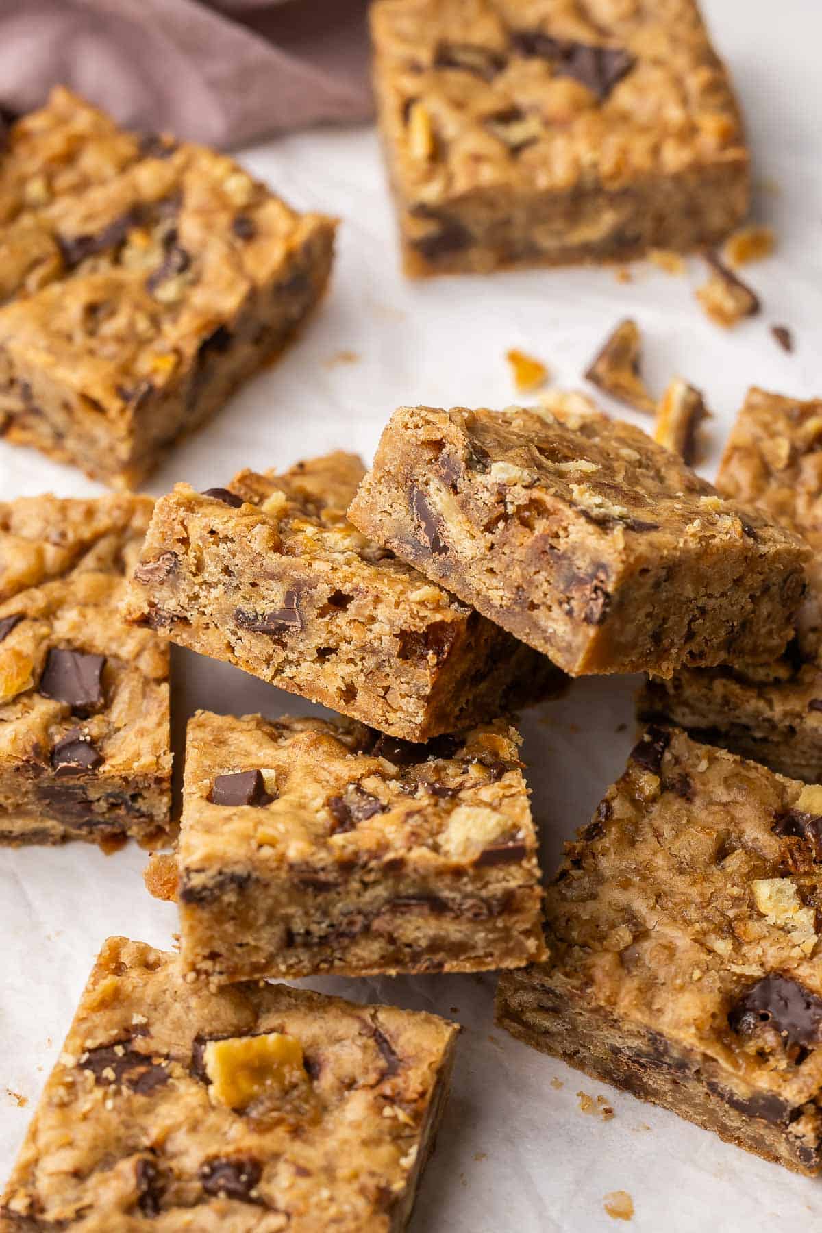 These Christmas Crack Blondies are chewy, buttery bars packed with caramel-chocolate cracker toffee. Made in just 45 minutes, they’re the perfect mash-up of two classic desserts! #dessert #recipe | dessert recipes | christmas recipes | christmas desserts | chocolate | caramel christmas crack blondies piled on top of each other.