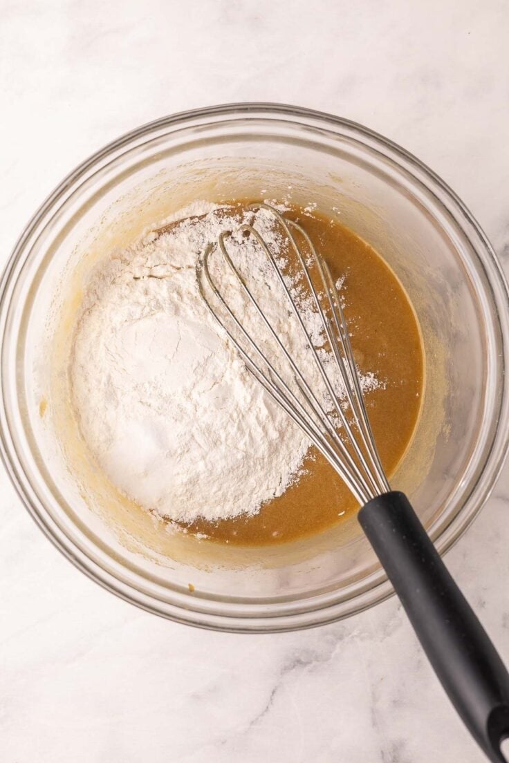 flour added to blondie ingredients in glass mixing bowl.