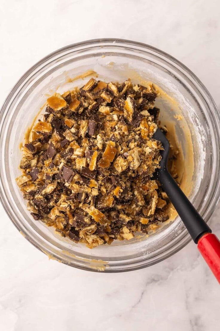 chopped christmas crack added to glass mixing bowl.