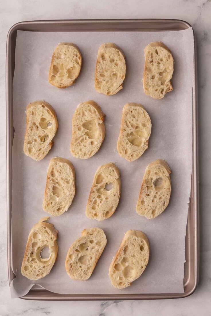 slices of baguette on a parchment lined pan.