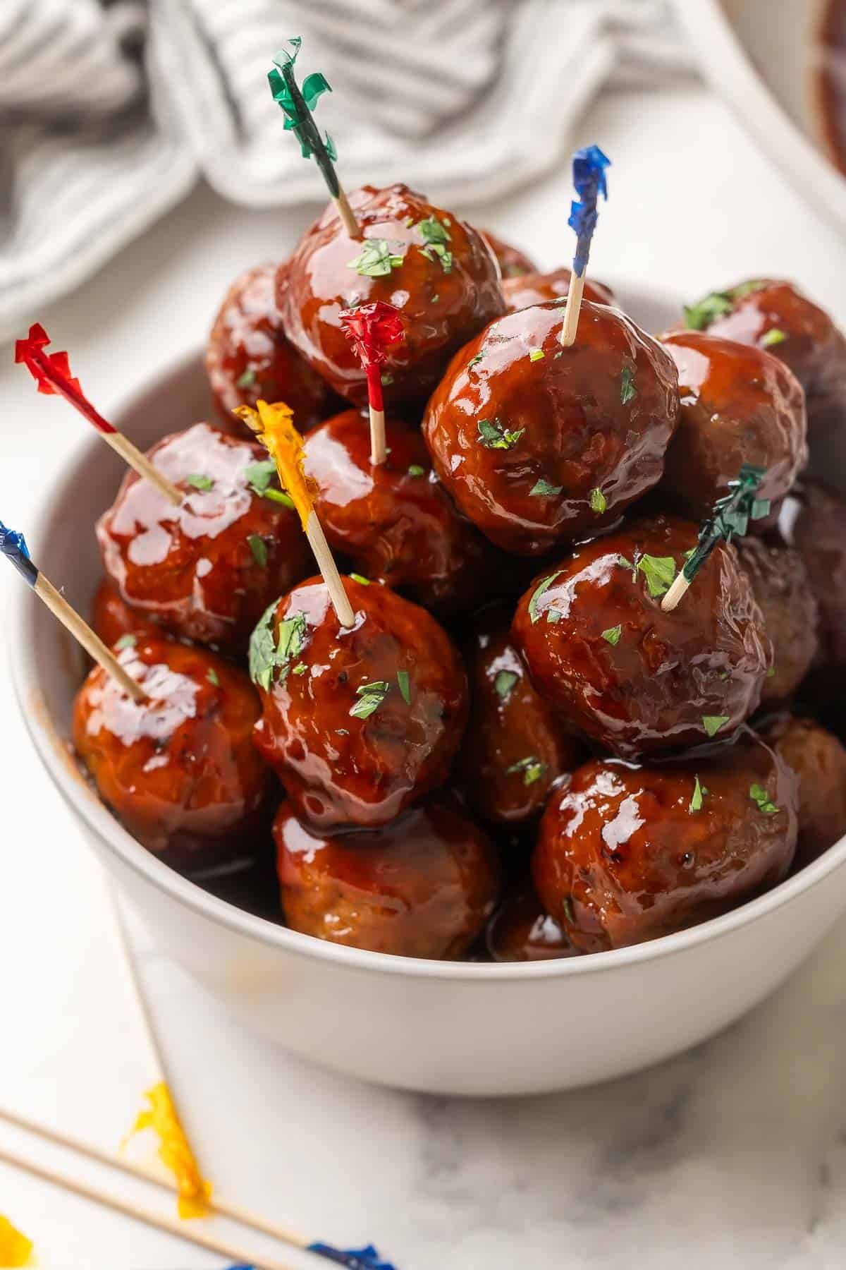 a bowl full of meatballs with toothpicks.