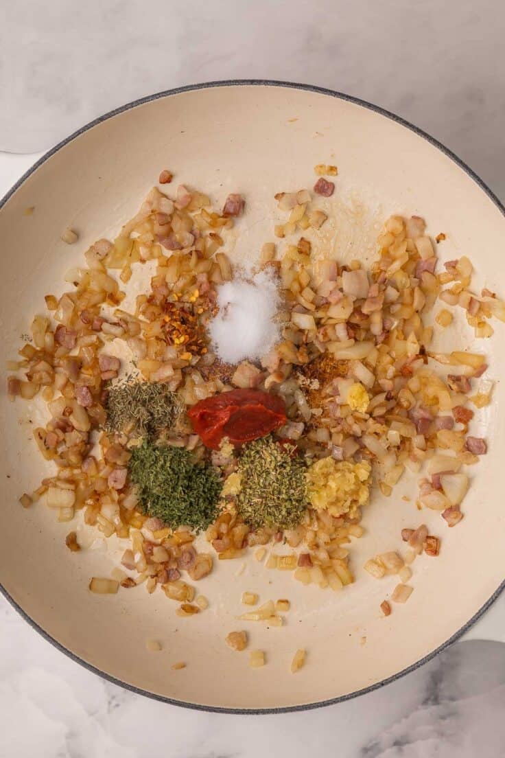 sauteed onions and spices in white pan.