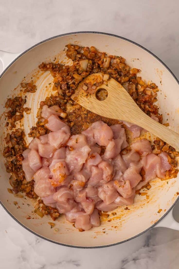 cubed chicken added to pan with spices.