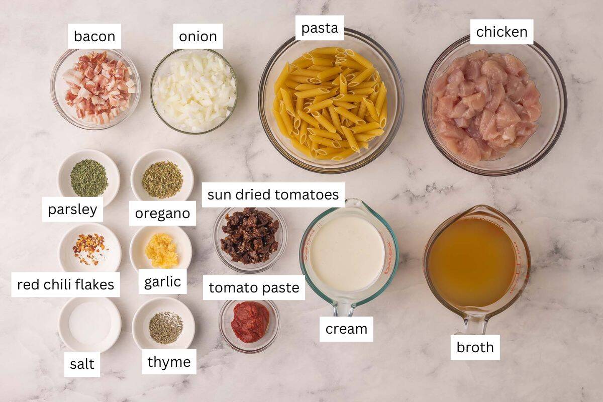 This One Pan Marry Me Chicken Pasta is packed with smoky bacon, juicy chicken breast, and nestled in a creamy sun-dried tomato sauce. It's a marriage proposal and cozy dinner all ready in 40 minutes that will make anyone say, "I do!" #pasta #recipe | dinner ideas | dinner recipes | one pan meal | one pot pasta | chicken breast recipes ingredients needed for marry me chicken pasta in bowls.