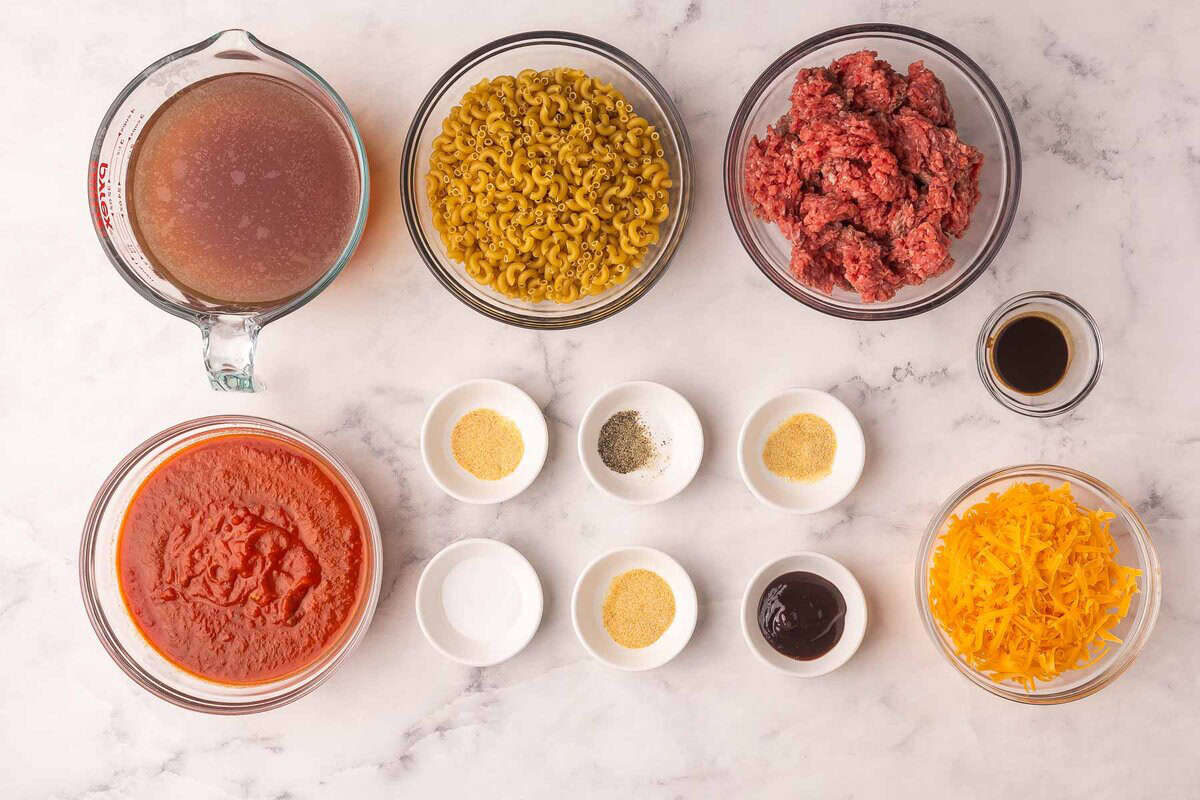 This cheesy No Boil Baked Cheeseburger Pasta is a 35-minute dinner winner! Everything cooks in one dish, which means no boiling, no browning, just cheesy, beefy goodness. #pasta #recipe #dinner | easy dinner ideas | dinner recipes | ground beef recipes | casseroles | make ahead meals | pasta bake ingredients needed for baked cheeseburger pasta in bowls.