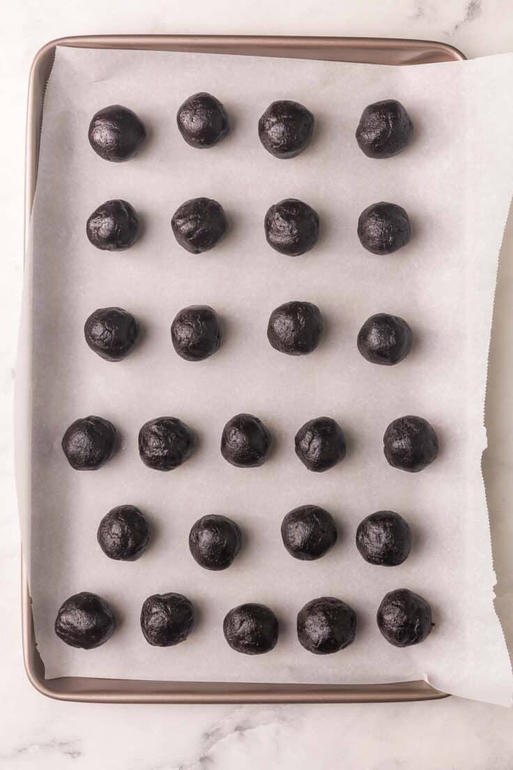 oreo balls on a lined pan.