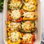 square overhead image of stuffed bell peppers in a baking dish.