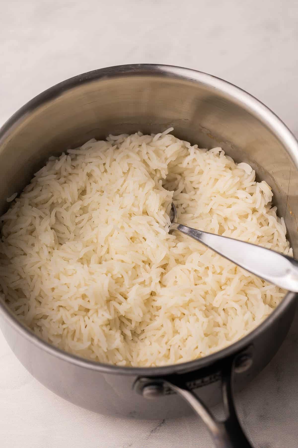 This Perfect Basmati Rice recipe is light, fluffy and never sticky! It takes just 20 minutes and comes out beautifully every single time. #rice #recipe #dinner | dinner recipes | easy recipes | how to cook rice | how to make rice | how to cook basmati rice | basmati rice recipe cooked basmati rice in a stainless steel pot.