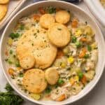 close up of a bowl of crockpot chicken pot pie with biscuits on top.