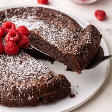 a slice of flourless chocolate cake being lifted off the plate.