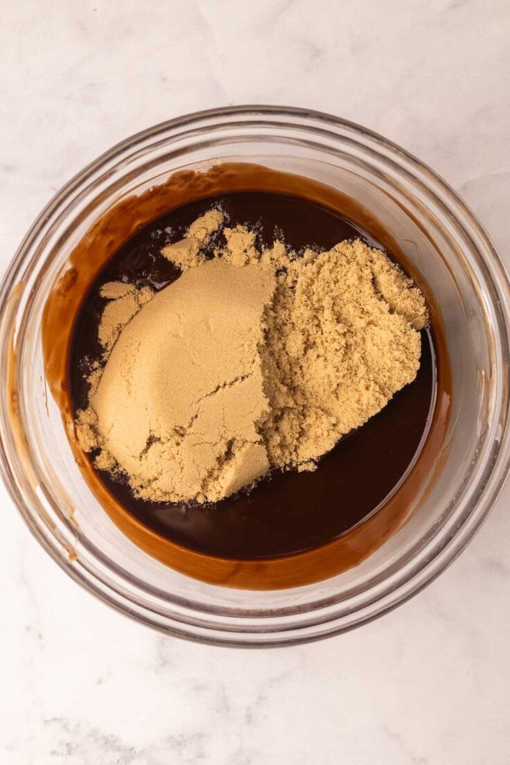 brown sugar added to melted chocolate in glass bowl.