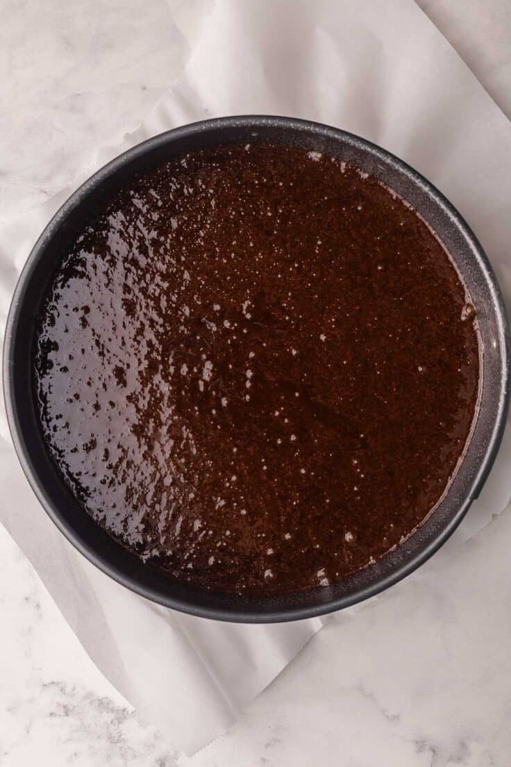 grey spring form pan filled with flourless chocolate cake batter.
