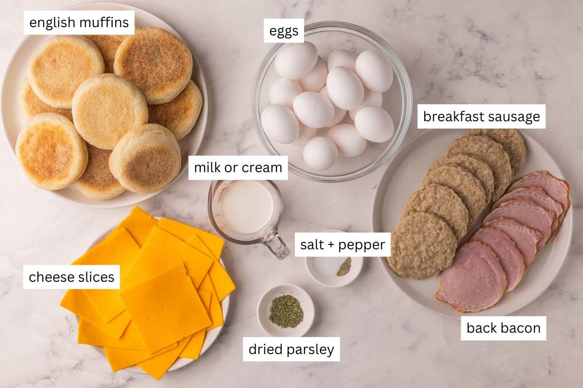 These Make Ahead Freezer Breakfast Sandwiches are hearty, cheesy, and freezer-friendly. Made with egg, cheese and your choice of meat, they're perfect for busy mornings, meal prep, or road trips! #freezermeal #breakfast #recipe | breakfast sandwich | freezer meals | breakfast prep | eggs | sausage | bacon | high protein ingredients needed for freezer breakfast sandwiches on plates and bowls.