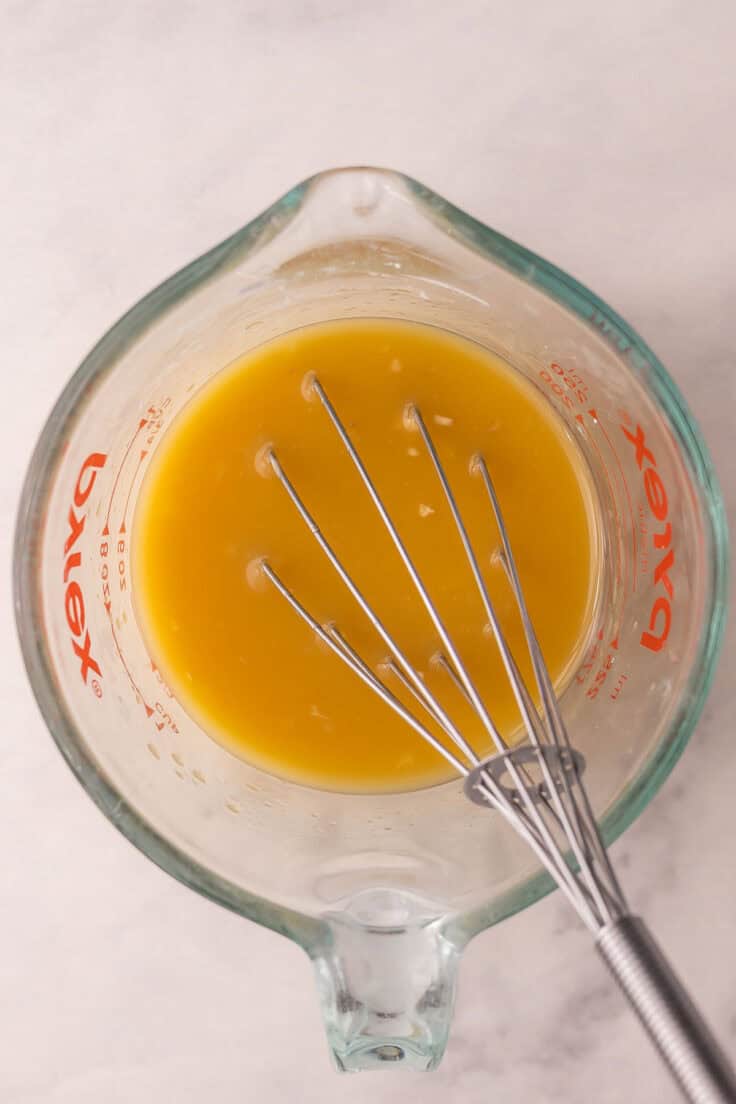 mango sauce whisked together in glass measuring cup.