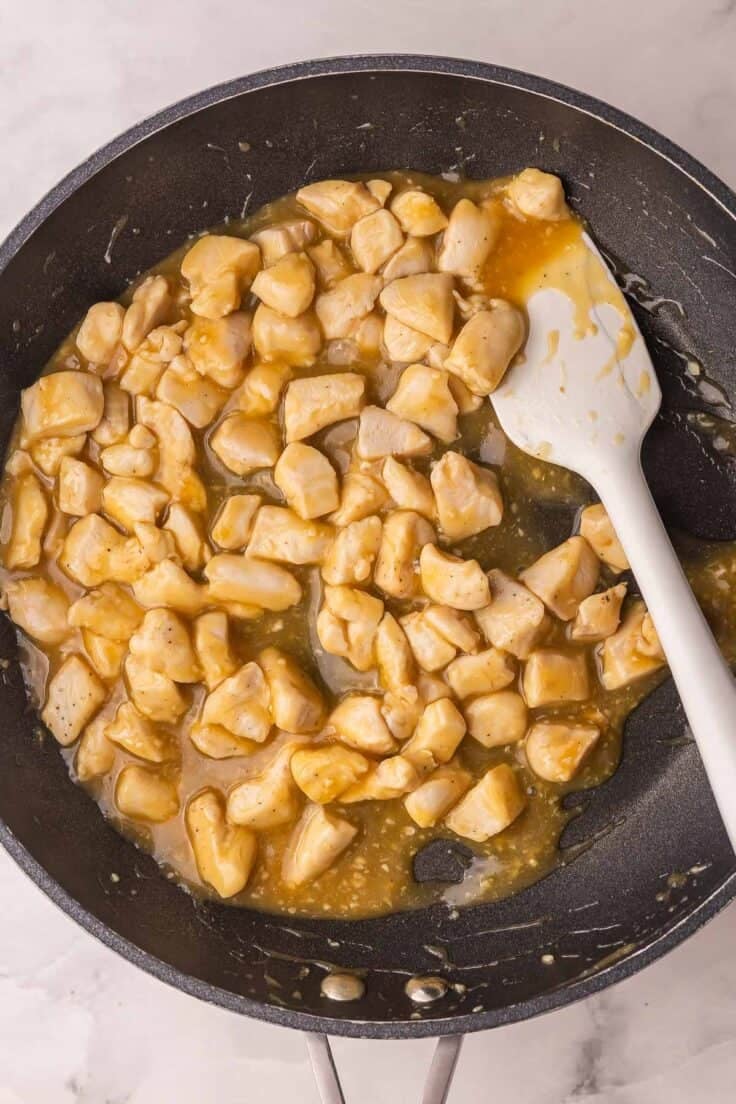 chicken with mango sauce in skillet cooked.