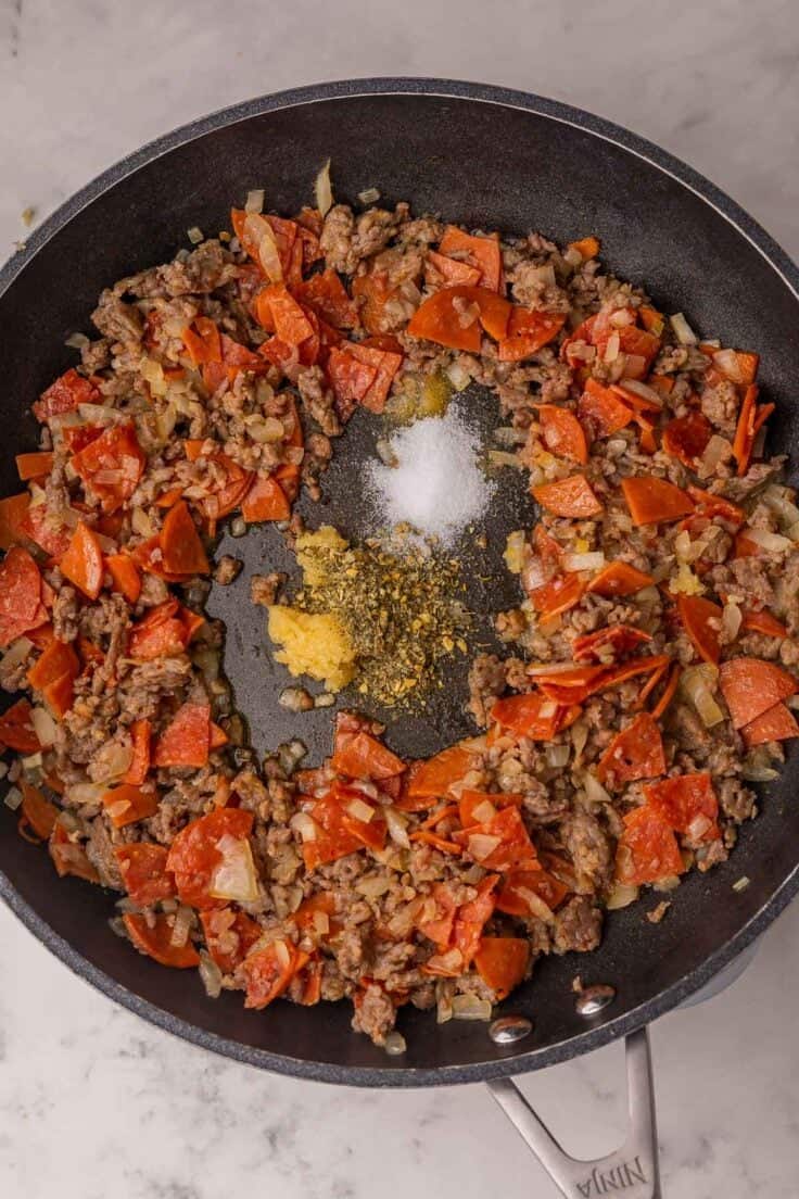 spices added to other ingredients in frying pan.