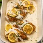 square image of baked lemon chicken in baking dish.