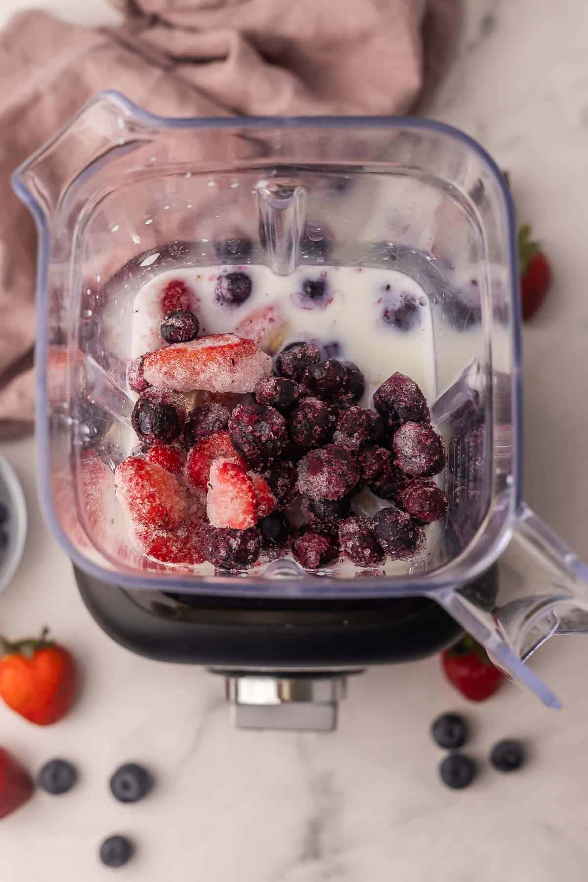 This easy Mixed Berry Smoothie is creamy, refreshing, and packed with strawberries, blueberries and raspberries! Ready in 5 minutes and is the perfect healthy breakfast or snack. #breakfast #smoothie #drink | summer drinks | healthy snack | healthy breakfast | blueberry | strawberry | raspberry ingredients for berry smoothie in a blender.