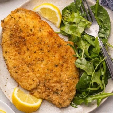 square image of crispy breaded chicken milanese with greens.