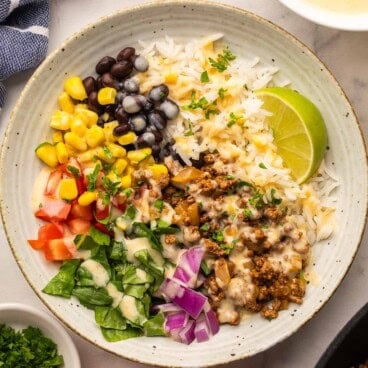 square image of ground beef burrito bowl with rice and toppings.