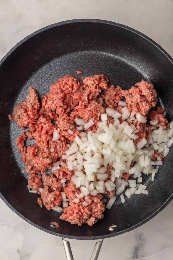 ground beef and onion in a black skillet.