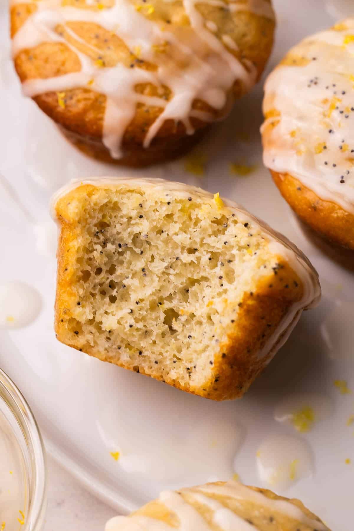 These fluffy Lemon Poppy Seed Muffins are light, zesty, and bakery-soft! Made with Greek yogurt for moisture and finished with a bright lemon glaze. #baking #recipe | muffin recipes | lemon recipes | baking from scratch | breakfast ideas | healthy snacks close up inside of lemon poppy seed muffin.