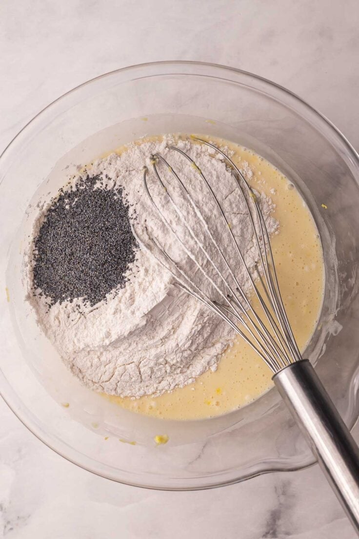 dry ingredients added to lemon muffins in mixing bowl.