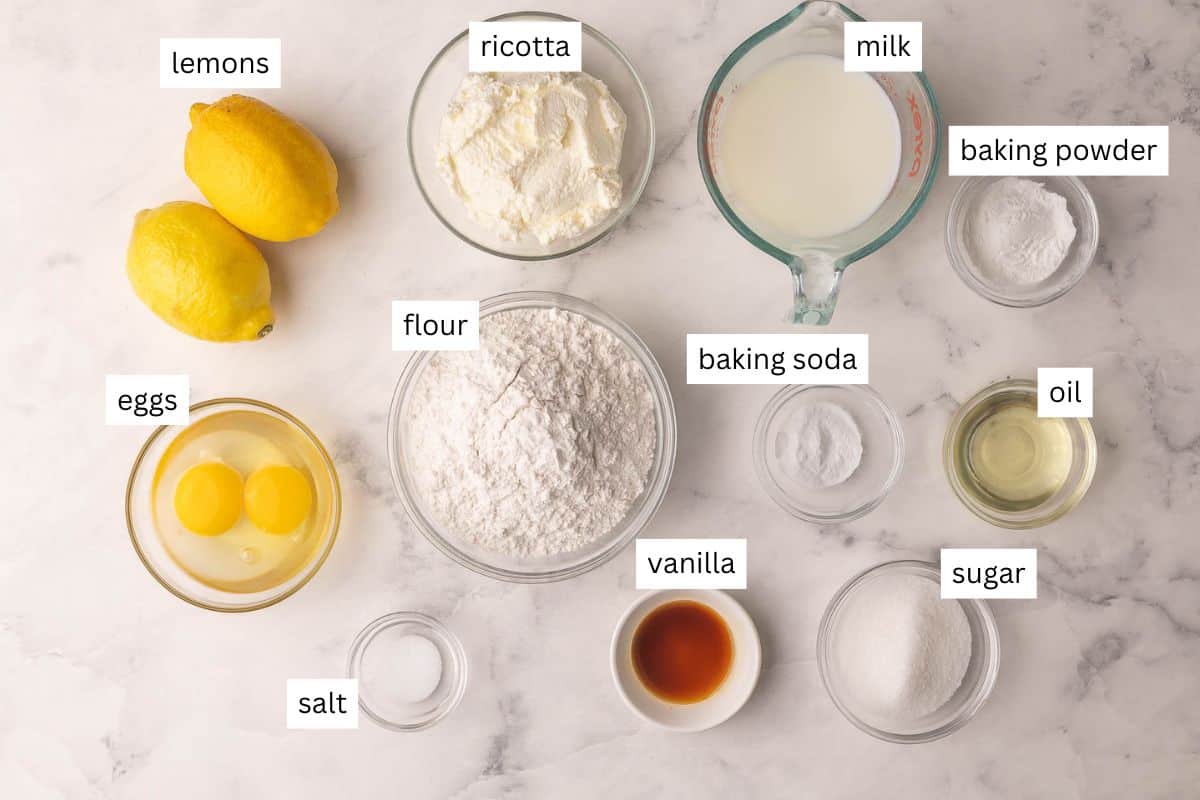 Light, fluffy Lemon Ricotta Pancakes with a burst of citrus and a hint of sweetness! With rich ricotta cheese, lemon juice and lemon zest they are full of flavor and will melt in your mouth. #lemon #pancakes #breakfast #recipe | breakfast recipes | lemon recipes | lemon pancakes | breakfast ideas | brunch recipes | mother's day | easter ingredients needed for lemon ricotta pancakes on marble background.