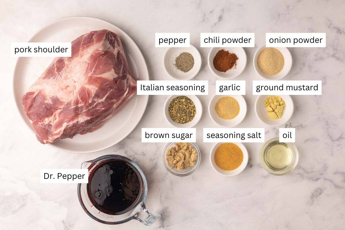 This Oven Pulled Pork recipe gives you the most tender, juicy pulled pork every single time! Seasoned with a bold spice rub and Dr. Pepper for rich, smoky-sweet flavor. #recipe #dinner #pork | pork recipes | pulled pork sandwich | sandwich recipes | barbecue | bbq | potluck | picnic | easy dinner ideas ingredients needed for pulled pork on a marble background.