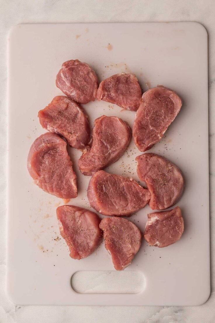 pork tenderloin cut into medallions on cutting board.