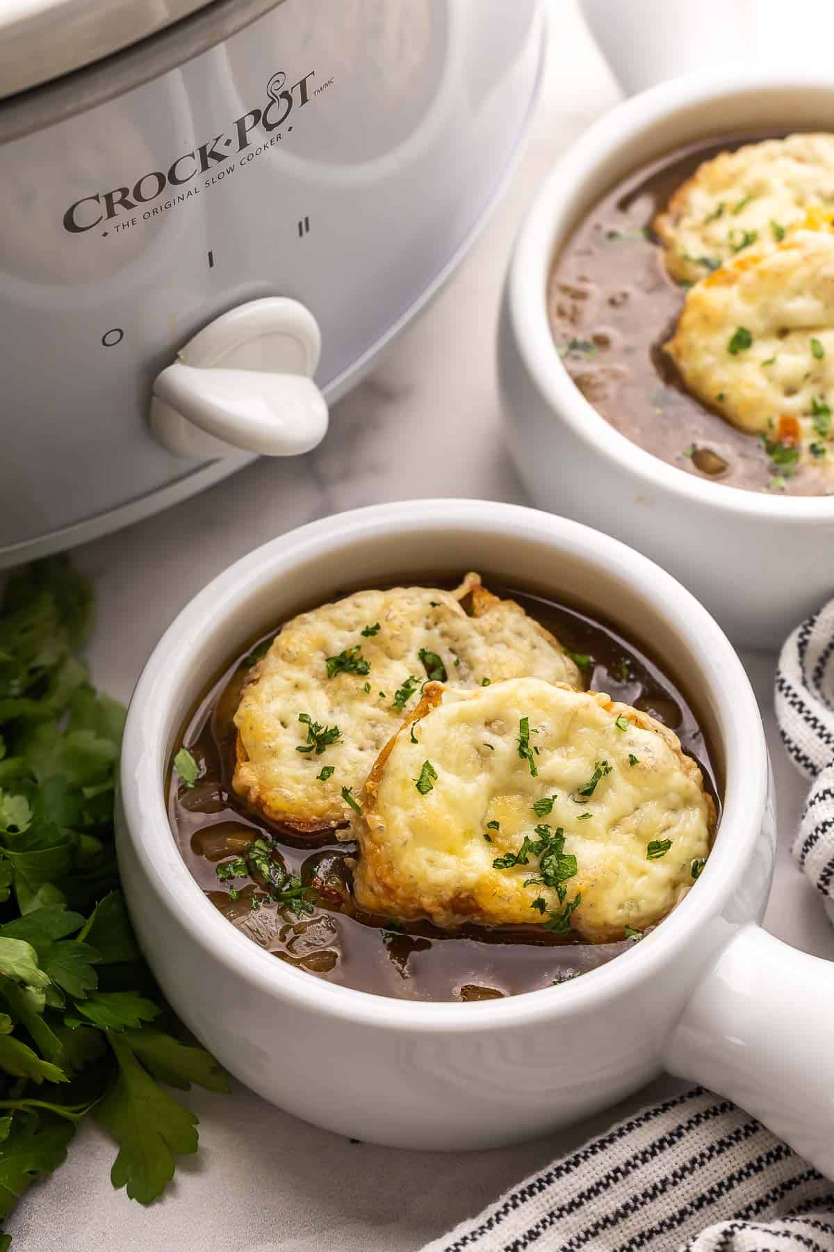 slow cooker french onion soup in white bowls.