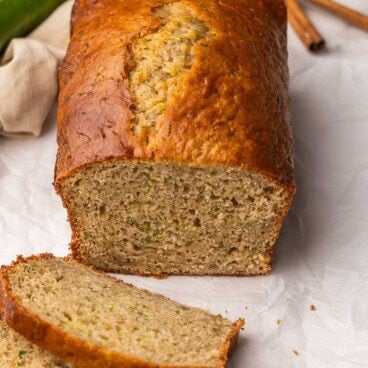 close up of some slices and a loaf of zucchini bread.