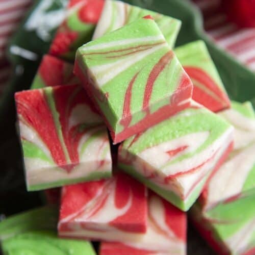 red green and white swirled christmas fudge stacked on a plate.