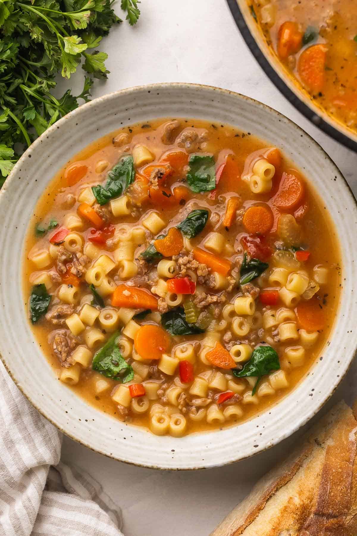 a speckled bowl full of italian sausage soup.