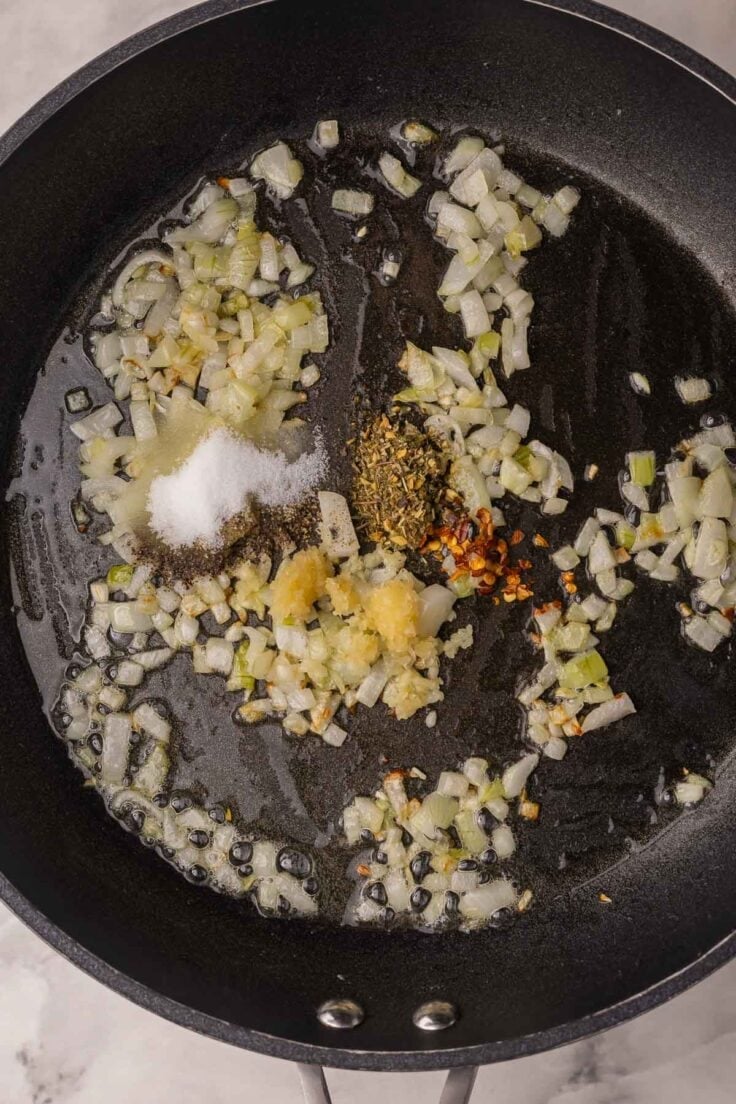 onions and seasonings sauteeing in black skillet.