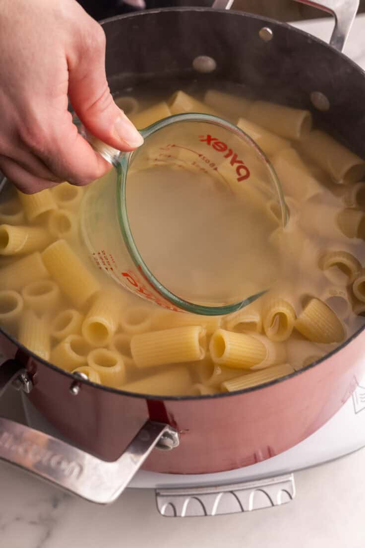 reserving pasta water from the pot for rigatoni pasta.