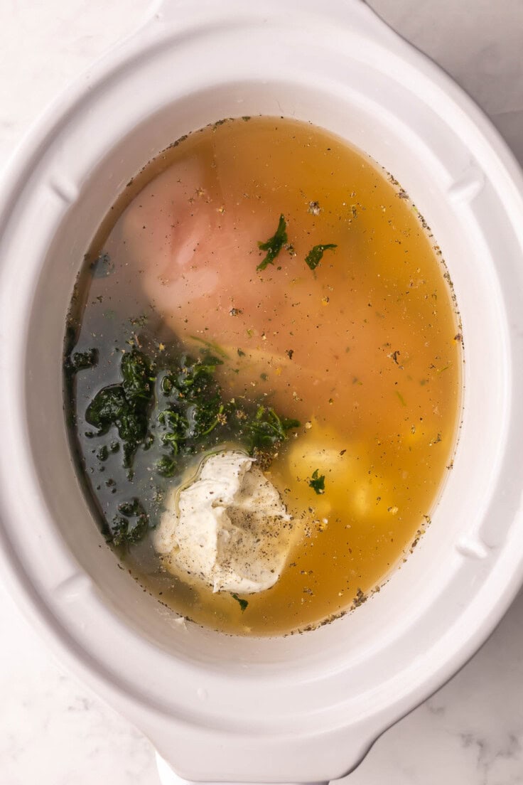 white crockpot filled with unmixed ingredients.