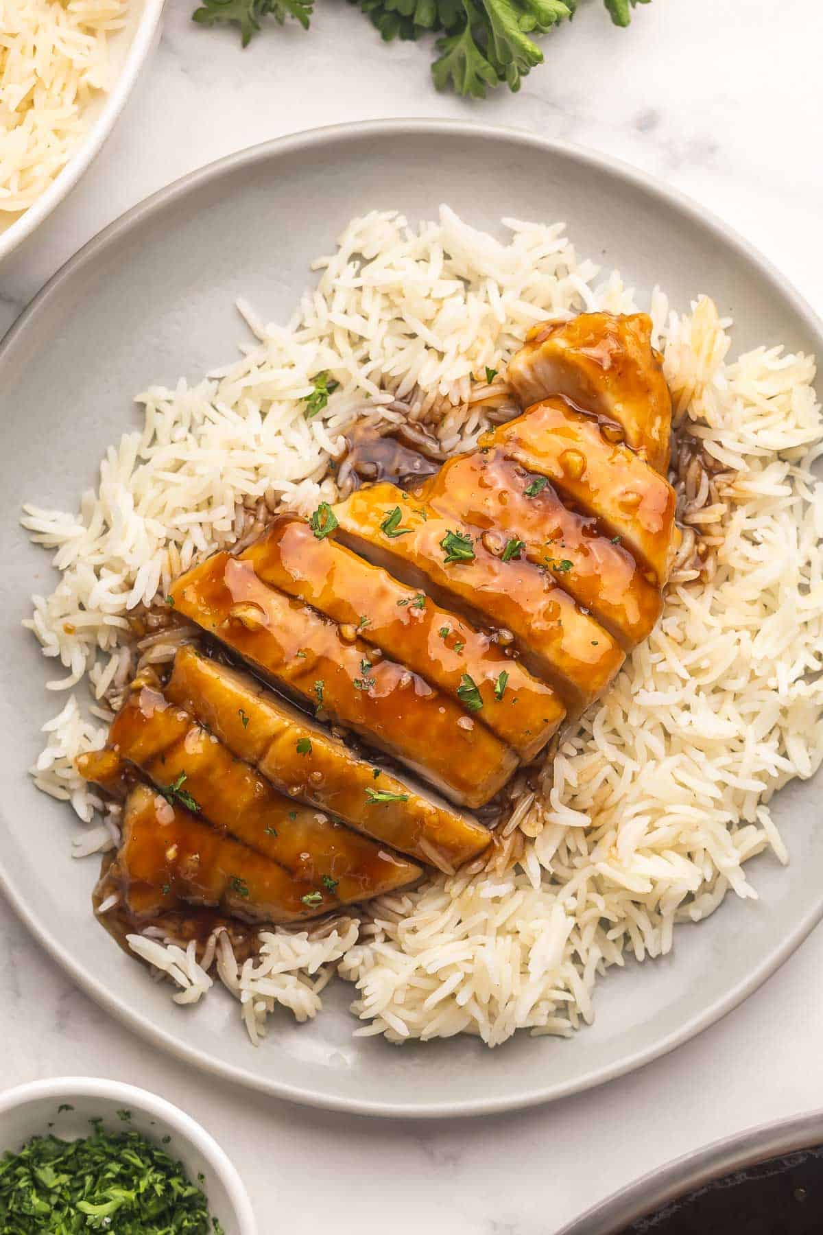 Honey Garlic Chicken is a 25-minute, one-skillet dinner with golden chicken breast in a sweet, sticky honey garlic sauce everyone devours! #chicken #recipe #dinner | dinner ideas | easy recipes | homemade takeout | chicken breast recipes | chicken dinners | meal prep | sauce recipe sliced honey garlic chicken on a plate of rice.