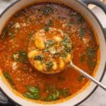 square image of sausage gnocchi soup with metal ladle scooping some.